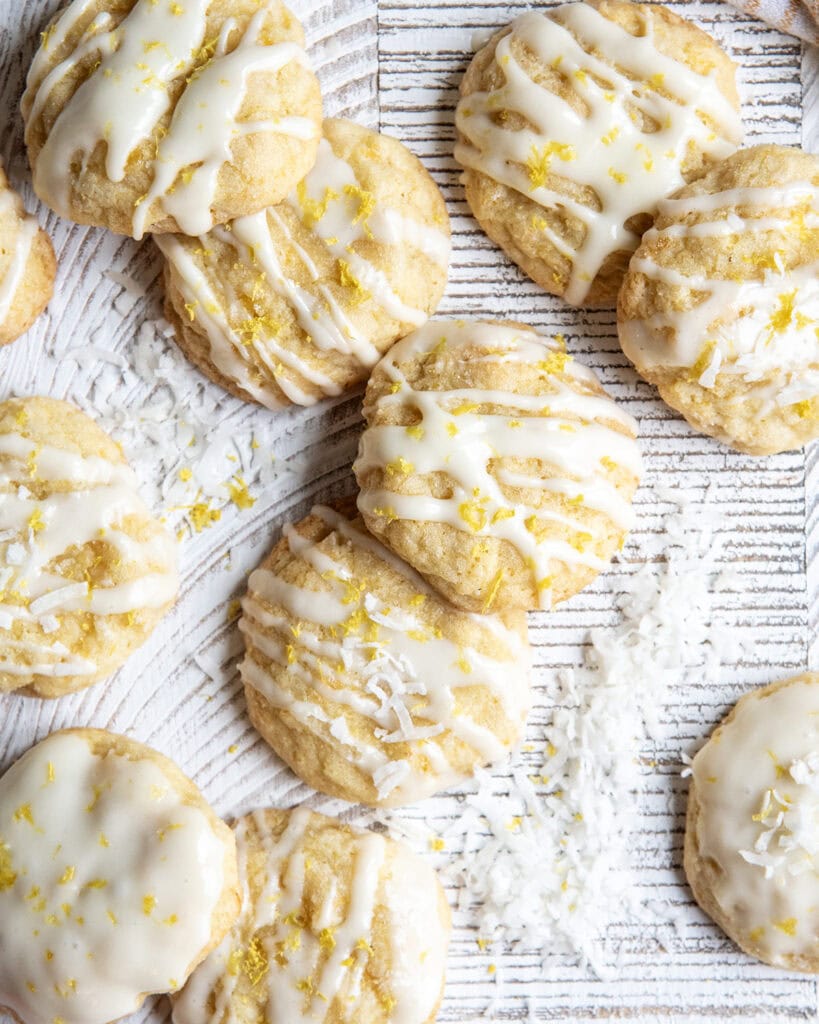 Cookies topped with drizzles of glaze on a white table.