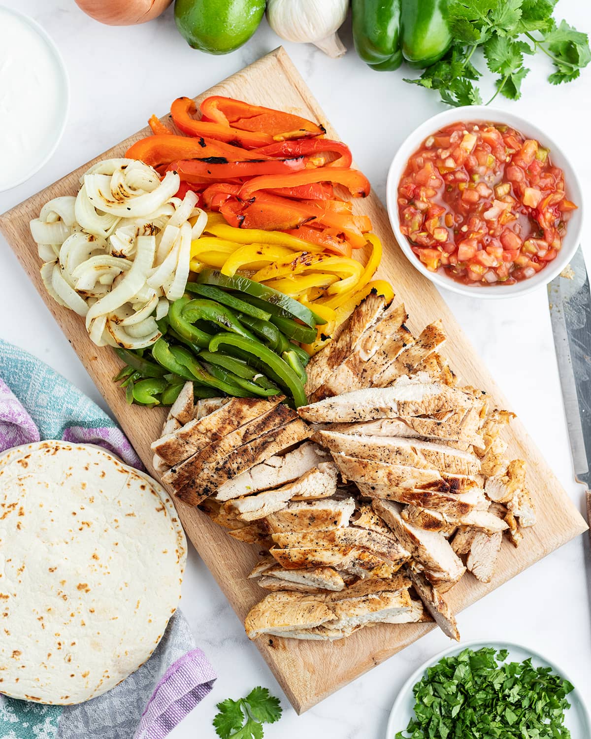 A tray of ingredients for chicken fajitas, with grilled chicken, bell peppers, and onion.