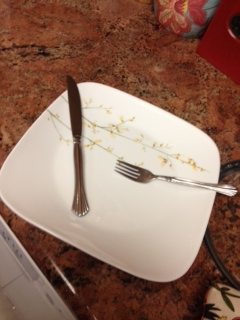 View of a fork and knife on a white plate.