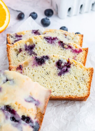 Slices of blueberry poppy seed bread laying on a piece of parchment paper.