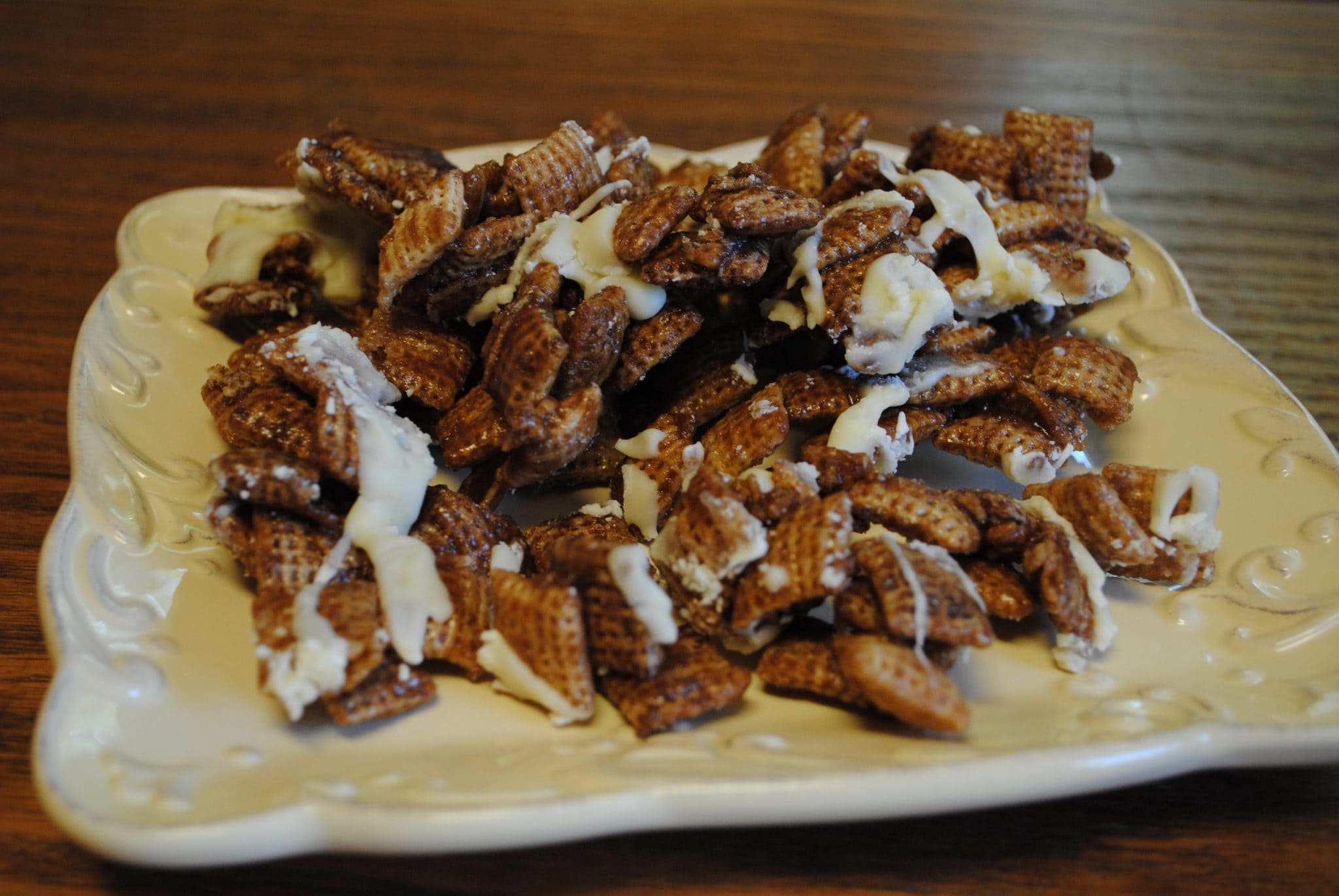 DSC_0704 Close up view of chocolate caramel chex mix on a white plate.