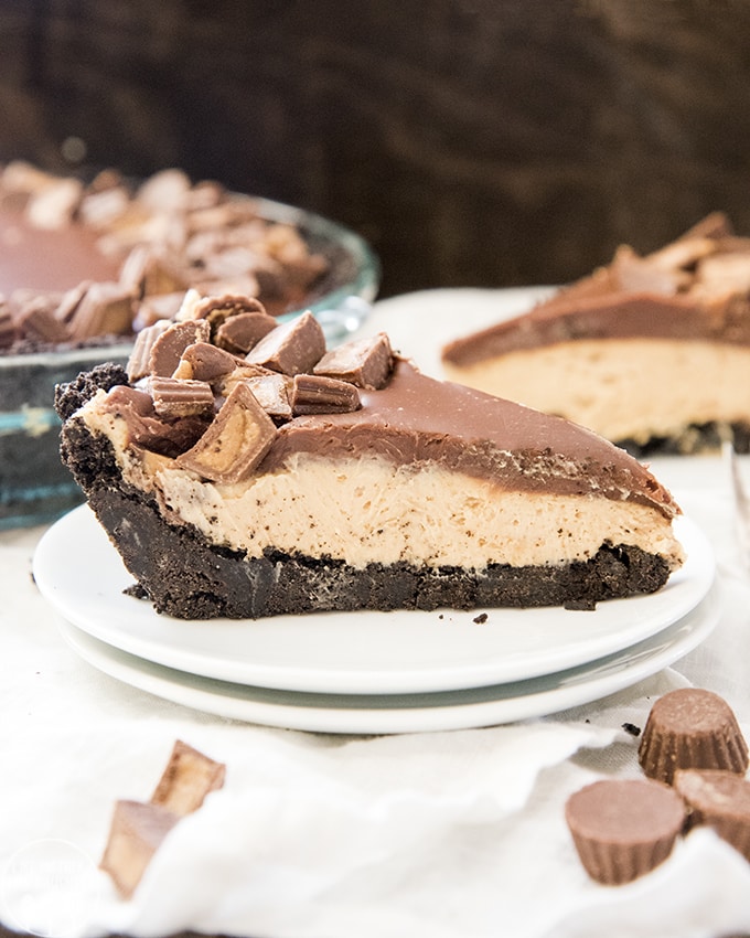 A slice of peanut butter pie topped with chocolate ganache on a plate. 