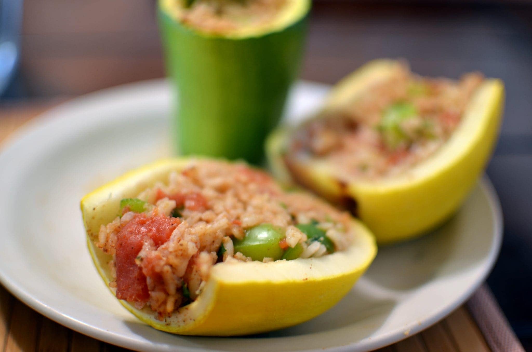 Angled view of stuffed squash with rice and tomatoes.
