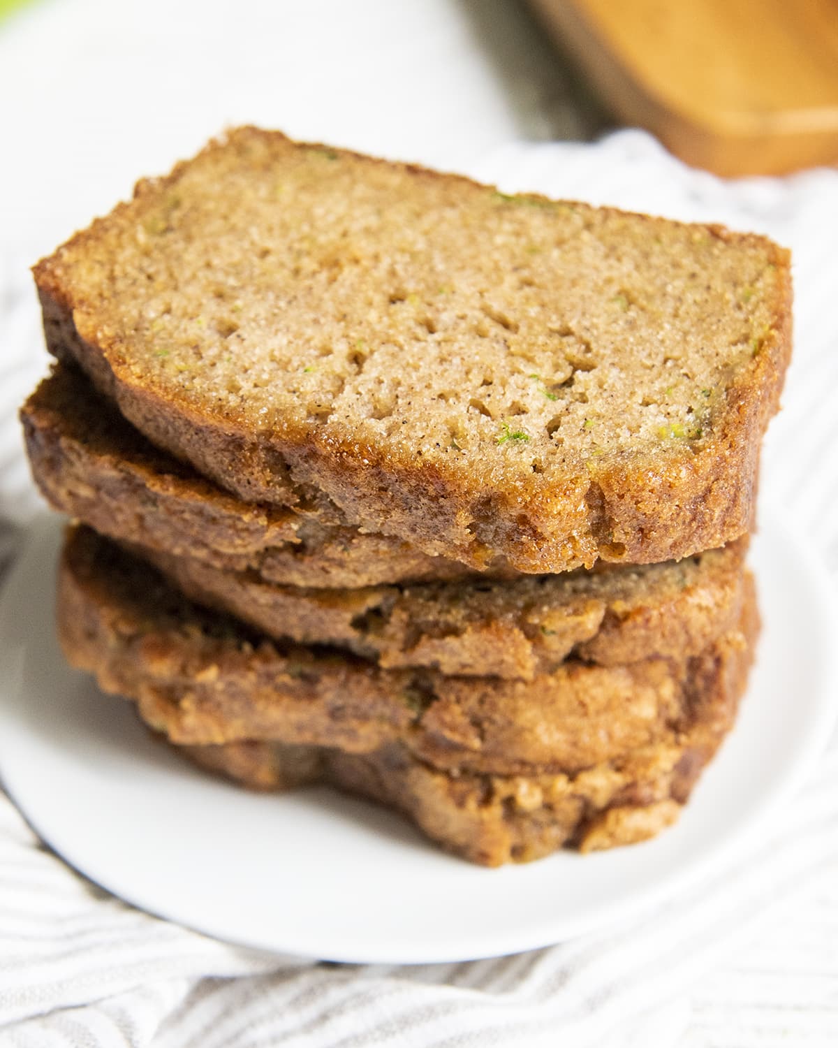 A stack of sliced zucchini bread pieces on a white plate.