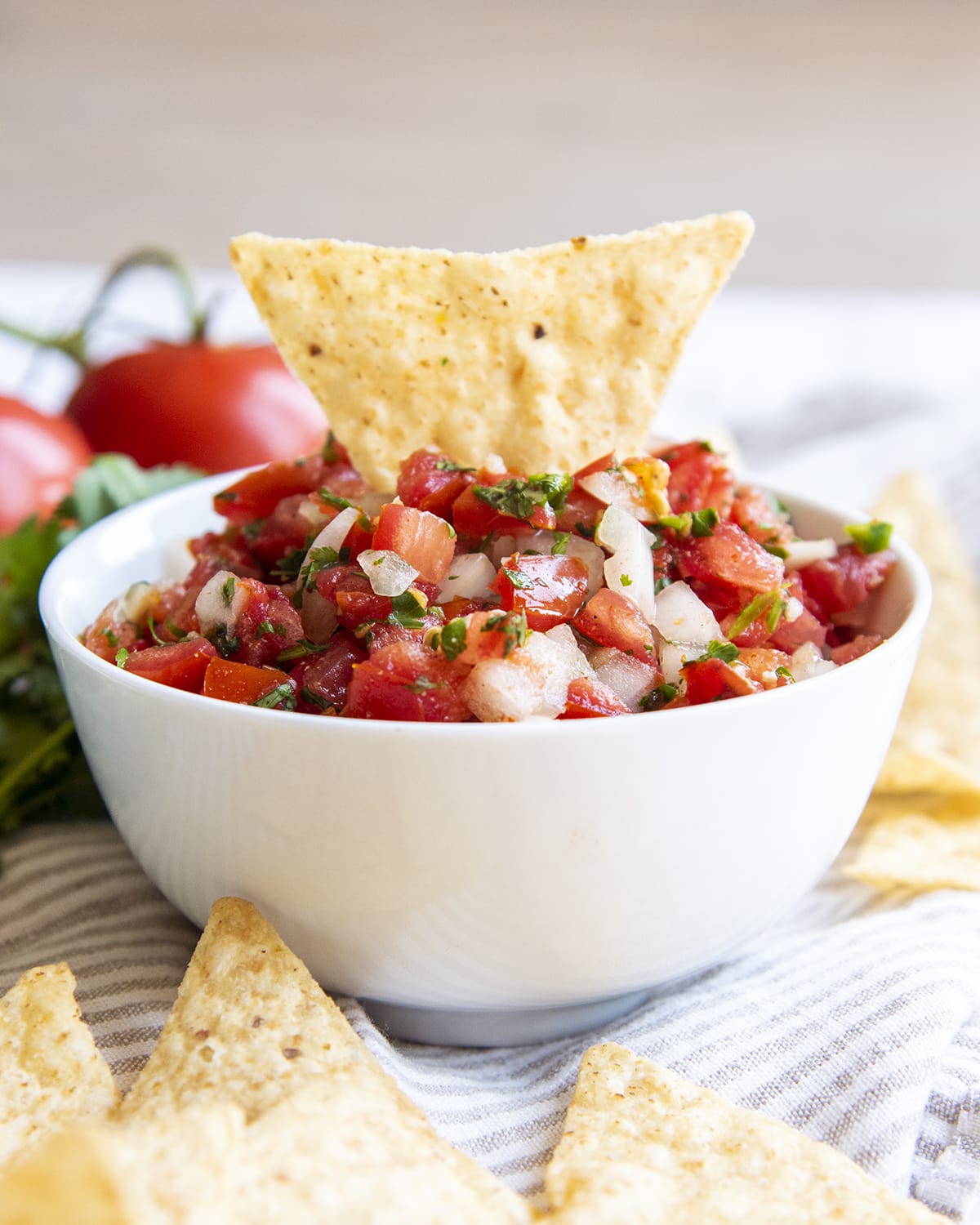 A tortilla chip sticking out of a bowl of homemade salsa.