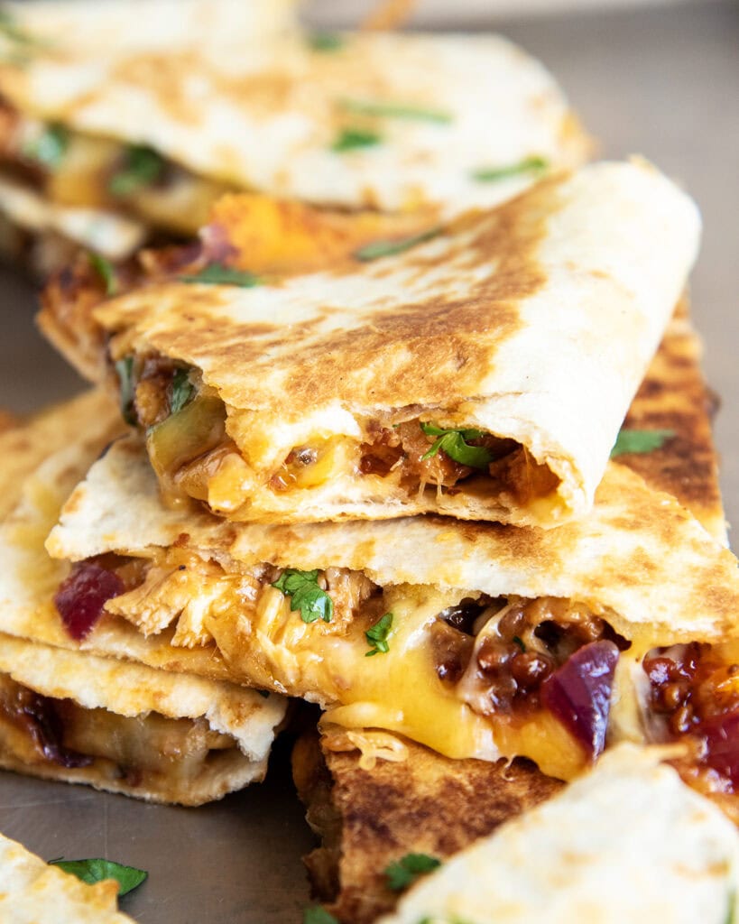 A stack of Barbecue Chicken Quesadilla slices, and one has a bite out of it.