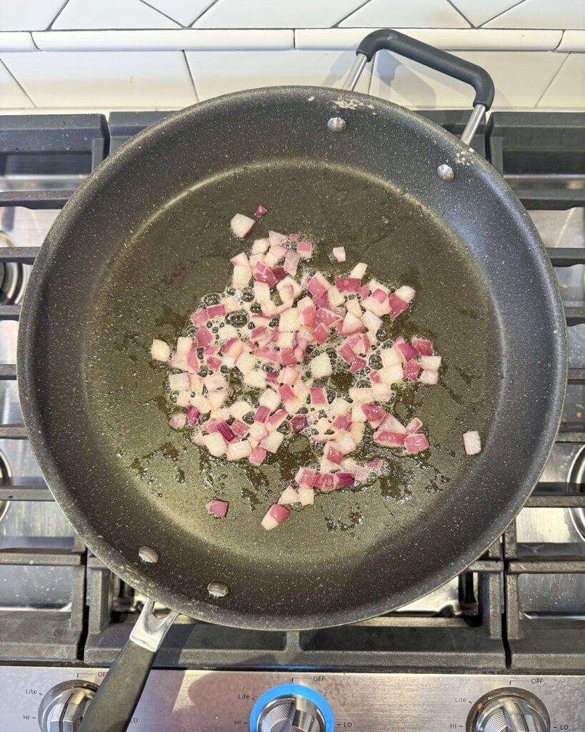 A skillet of sauteed red onions. 