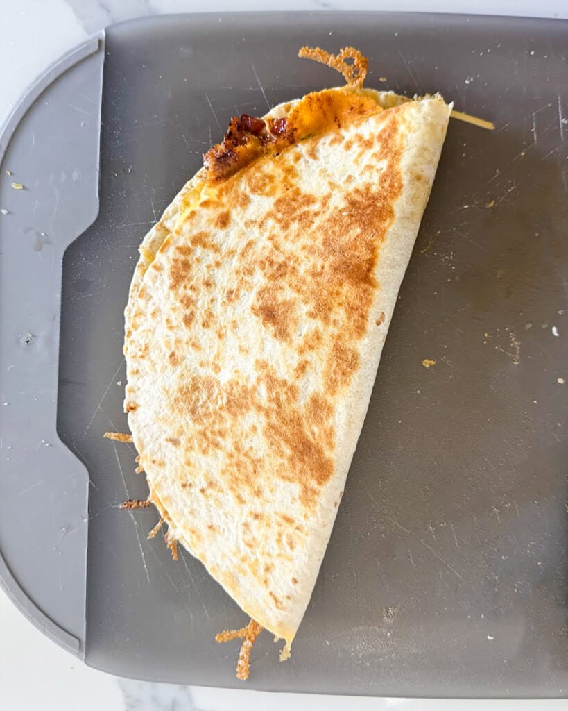 A cooked quesadilla on a cutting board.