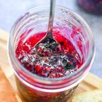 Raspberry blueberry jam in a jar with a spoon