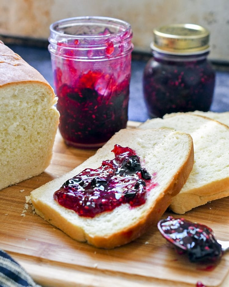 Raspberry blueberry jam spread on a slice of white bread