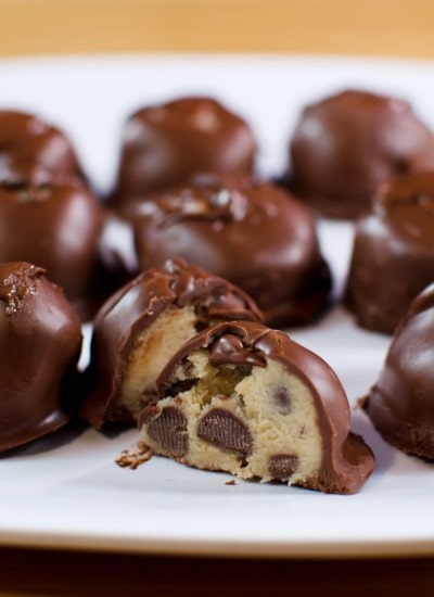 Front view cookie dough truffles on a white plate.