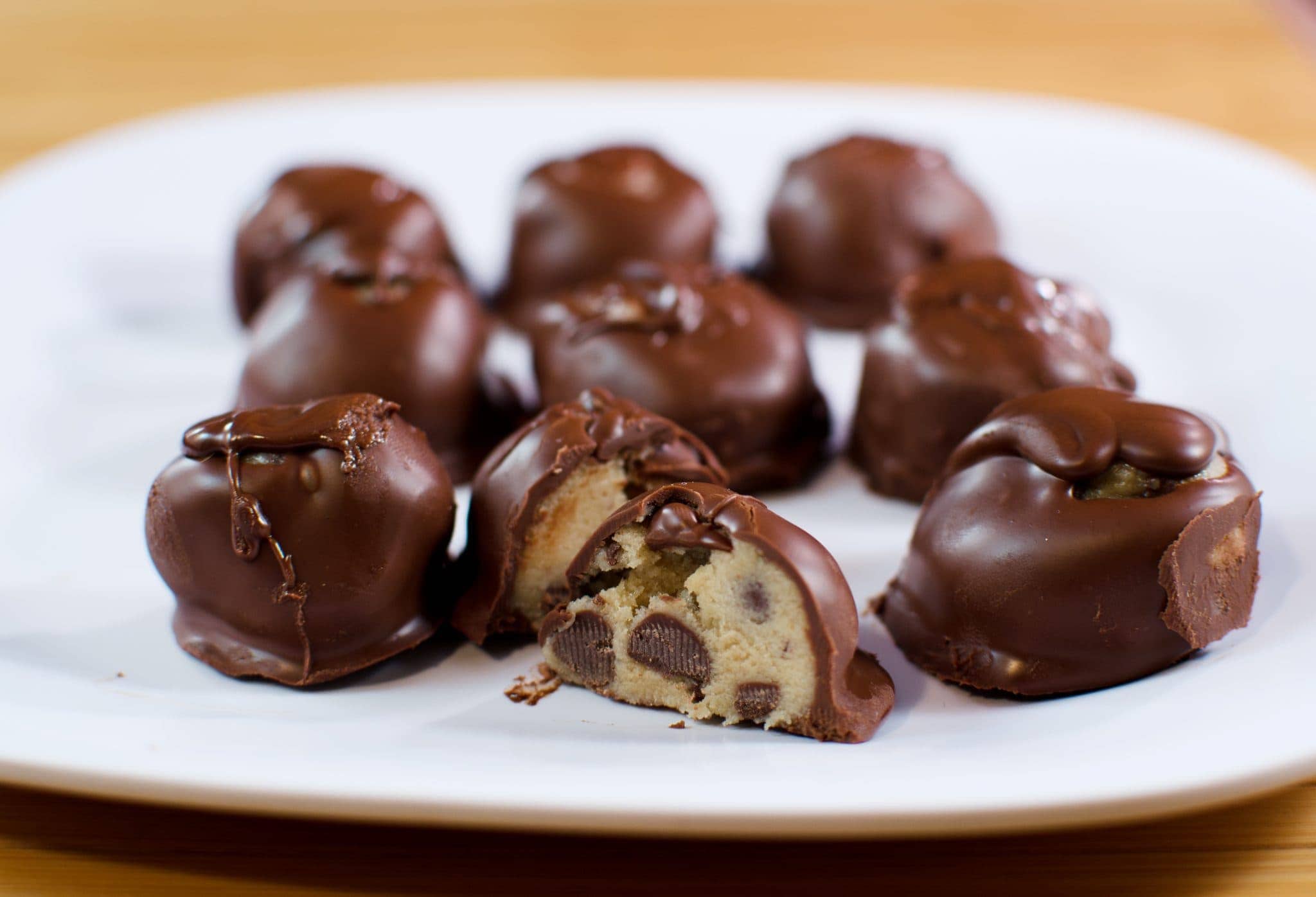 Front view cookie dough truffles on a white plate.