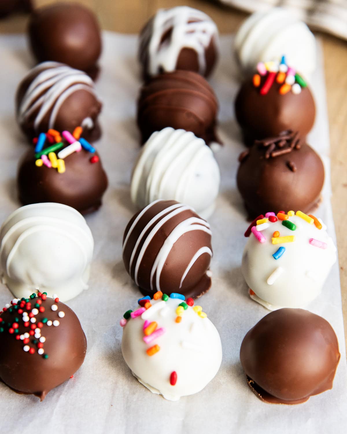 Rows of chocolate covered cookie dough truffles.