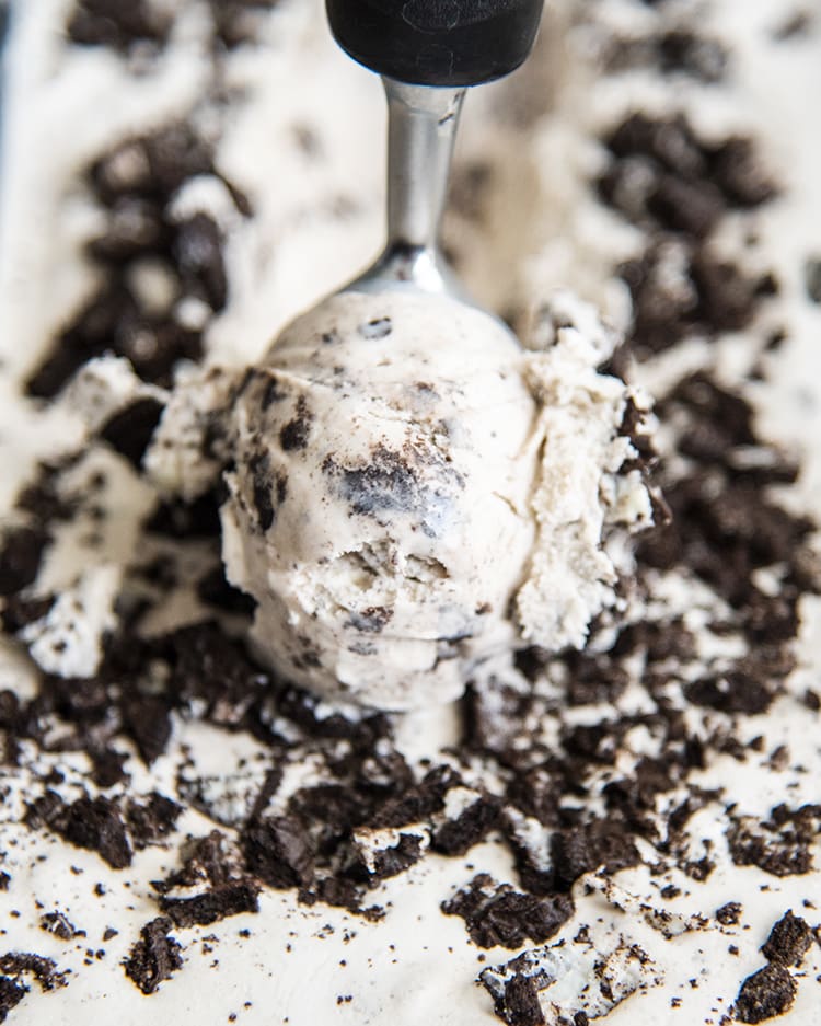 A scoop of cookies and cream ice cream being scooped with an ice cream scoop