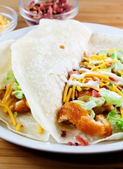 Angled view of buffalo ranch chicken tacos on a white plate.