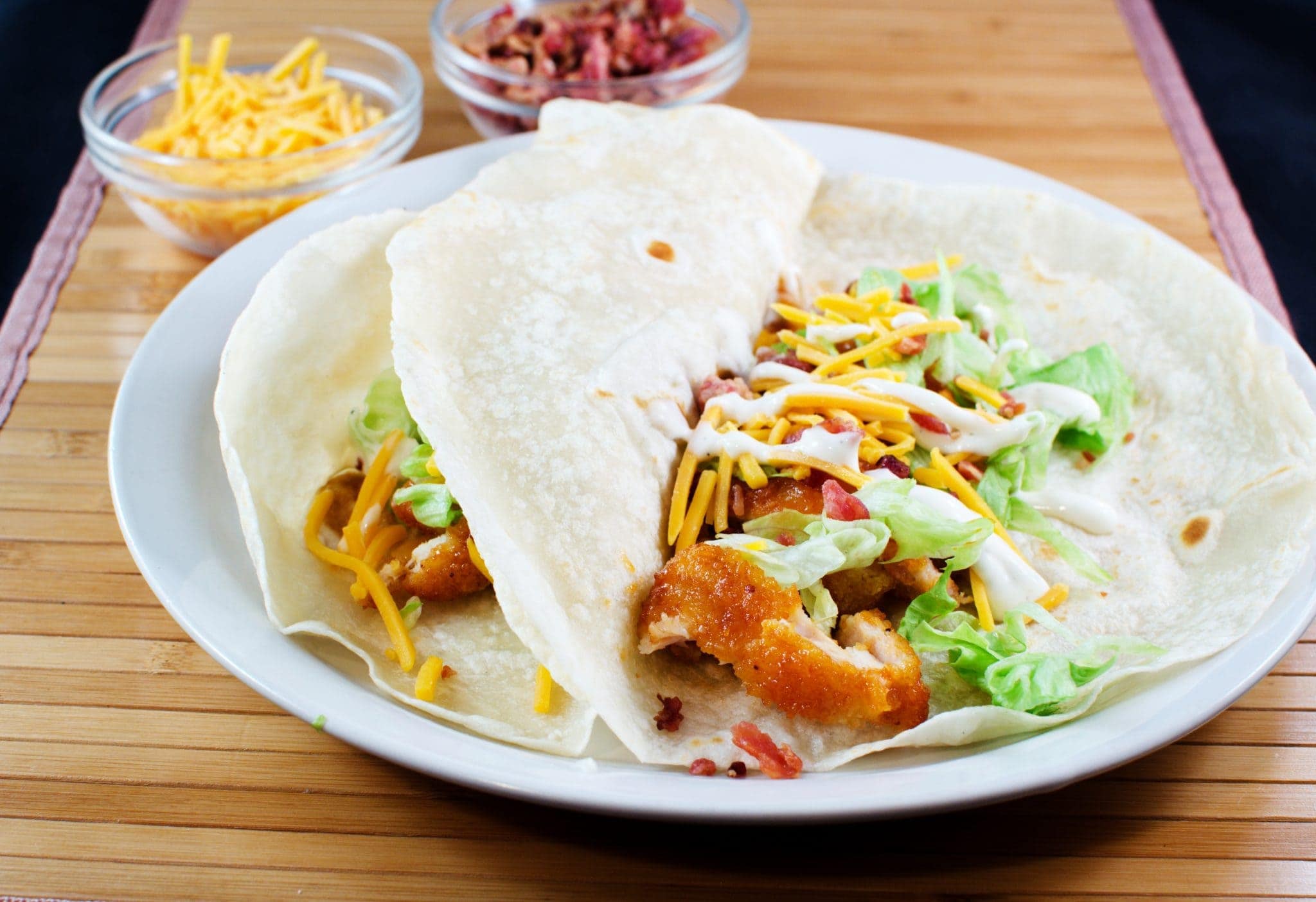 Angled view of buffalo ranch chicken tacos on a white plate.