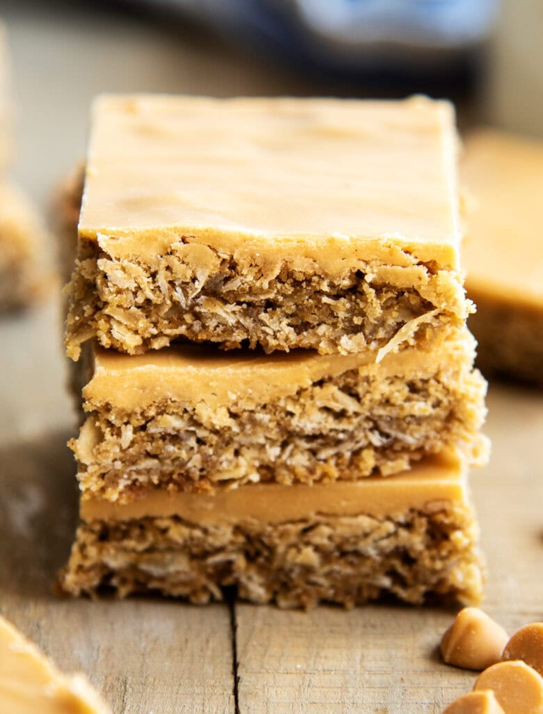 A close up of a stack of butterscotch bars on a wooden table.