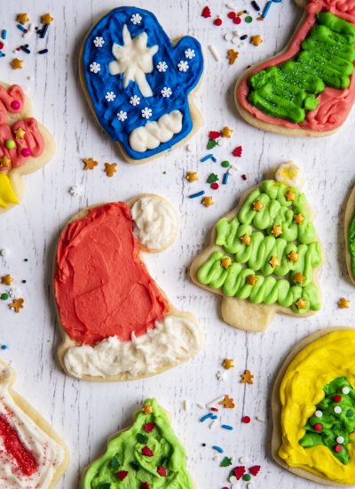 An overhead photo of frosted sugar cookies including a Santa hat cookie and a Christmas tree cookie.
