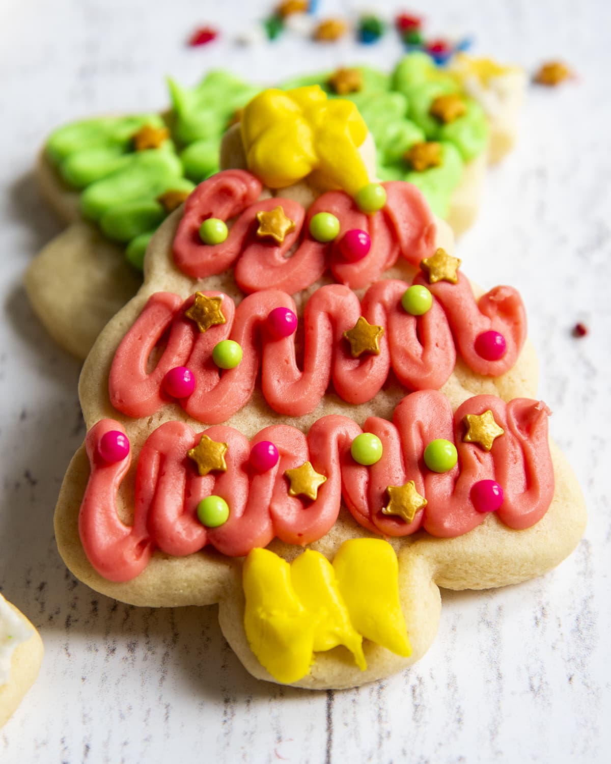 A pink decorated Christmas tree sugar cookie.