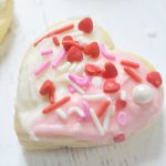 heart sugar cookie - half white frosting, half pink frosting with red, white, pink sprinkles