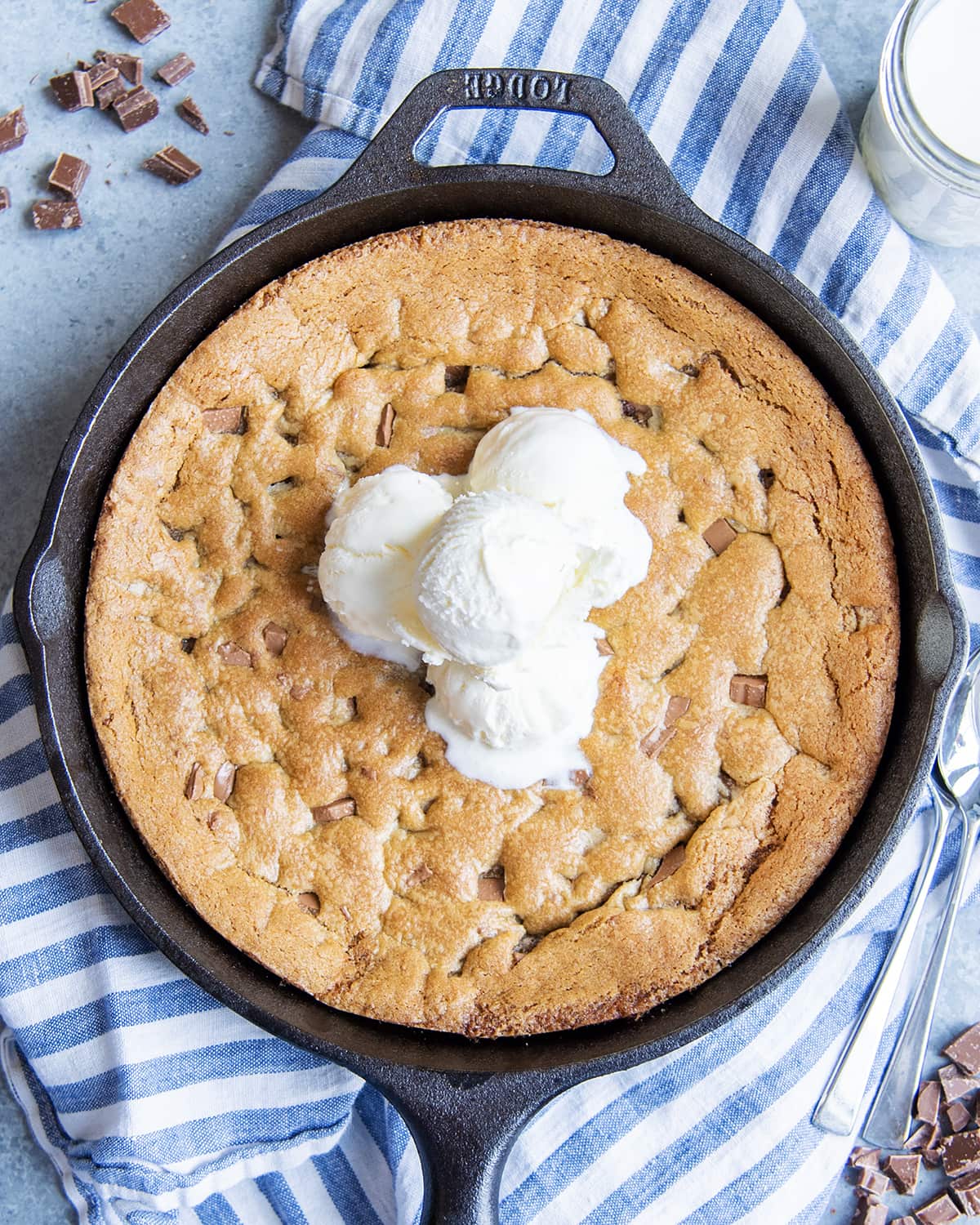 A chocolate chunk pizookie topped with scoops of vanilla ice cream.