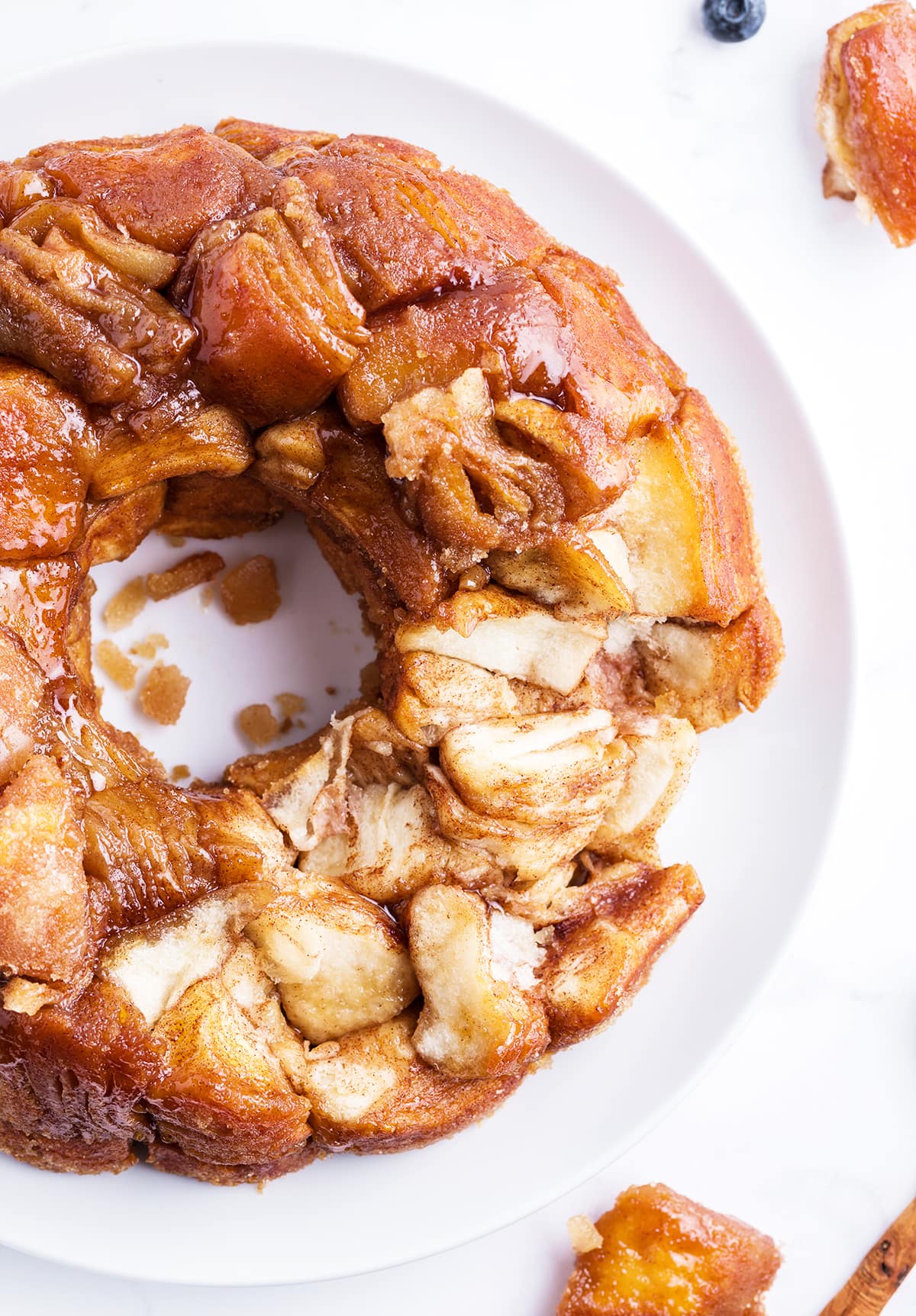 Monkey bread on a plate, with a few pieces taken out showing the inside of the bread.