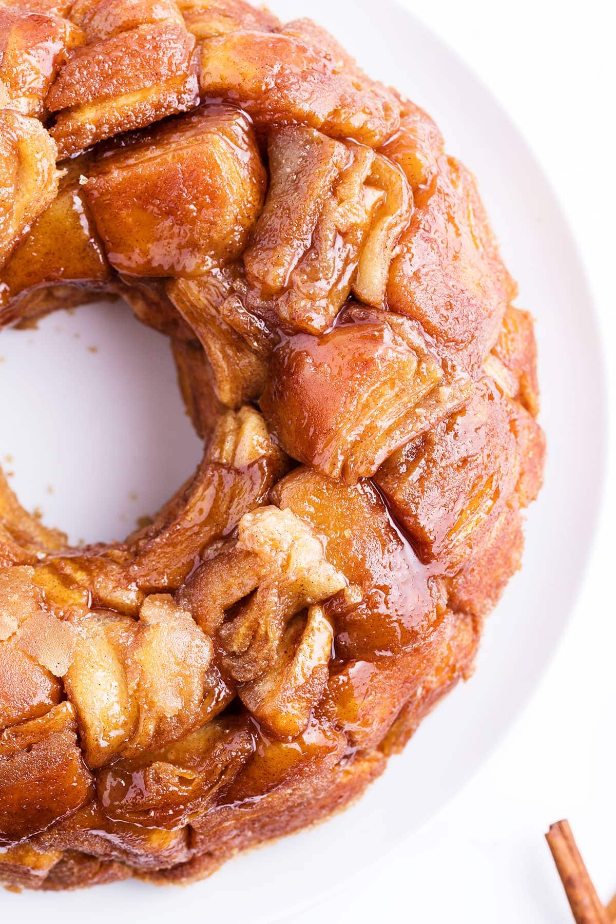 Monkey bread on a white plate, showing the pull apart pieces covered in caramel.
