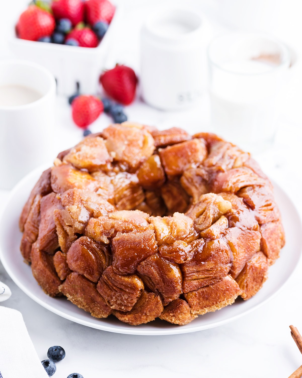 Pull apart monkey bread covered in caramelly sugar goodness, on a white plate.