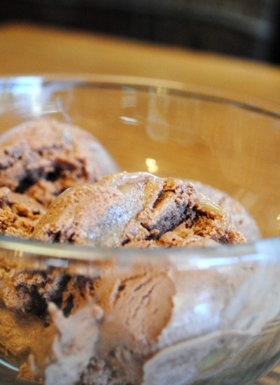 Angled view of homemade chocolate caramel ice cream in a glass bowl.