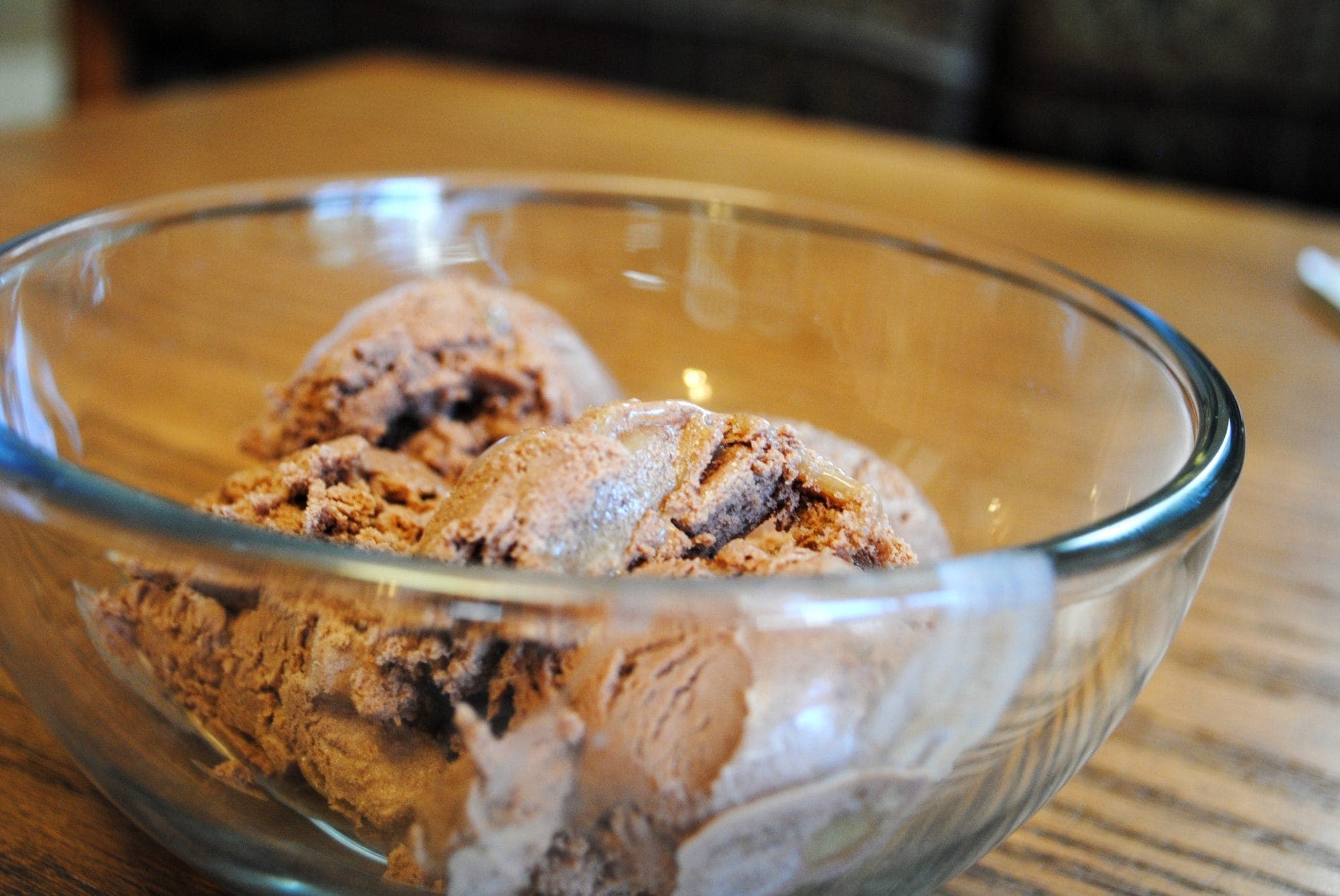 Angled view of homemade chocolate caramel ice cream in a glass bowl.