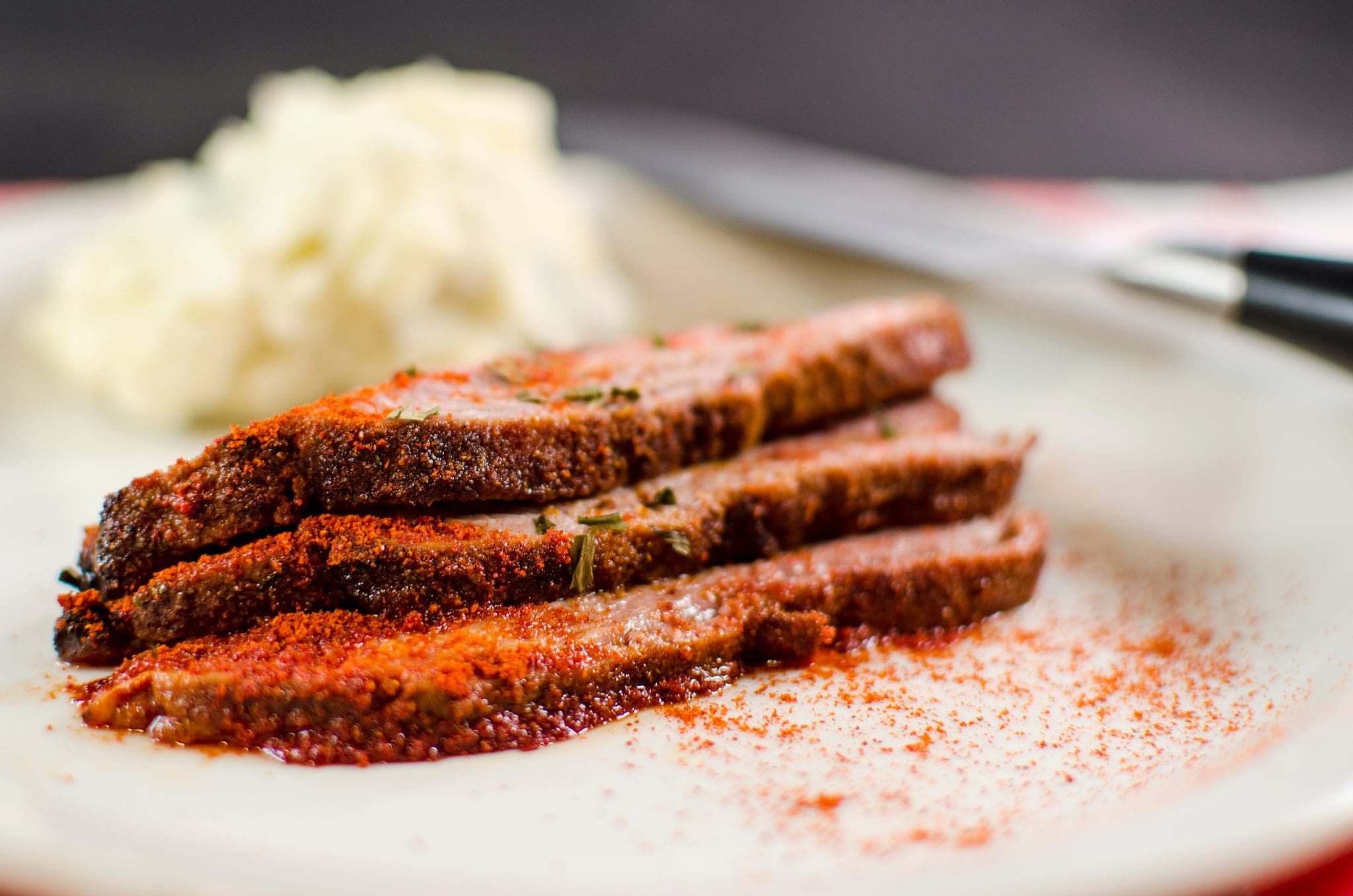 Side view of middle-eastern flank steak on a plate.