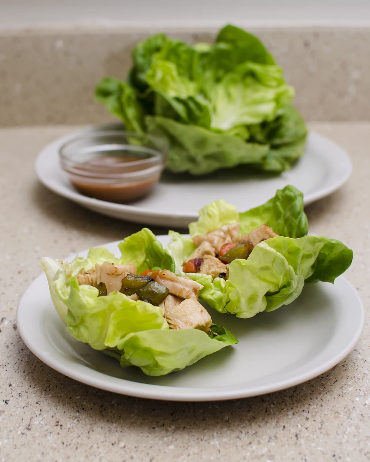 Front view of chicken lettuce wraps on a white plate.