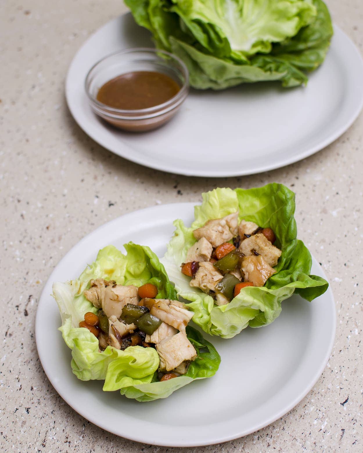 Angled view of chicken lettuce wraps on a white plate.