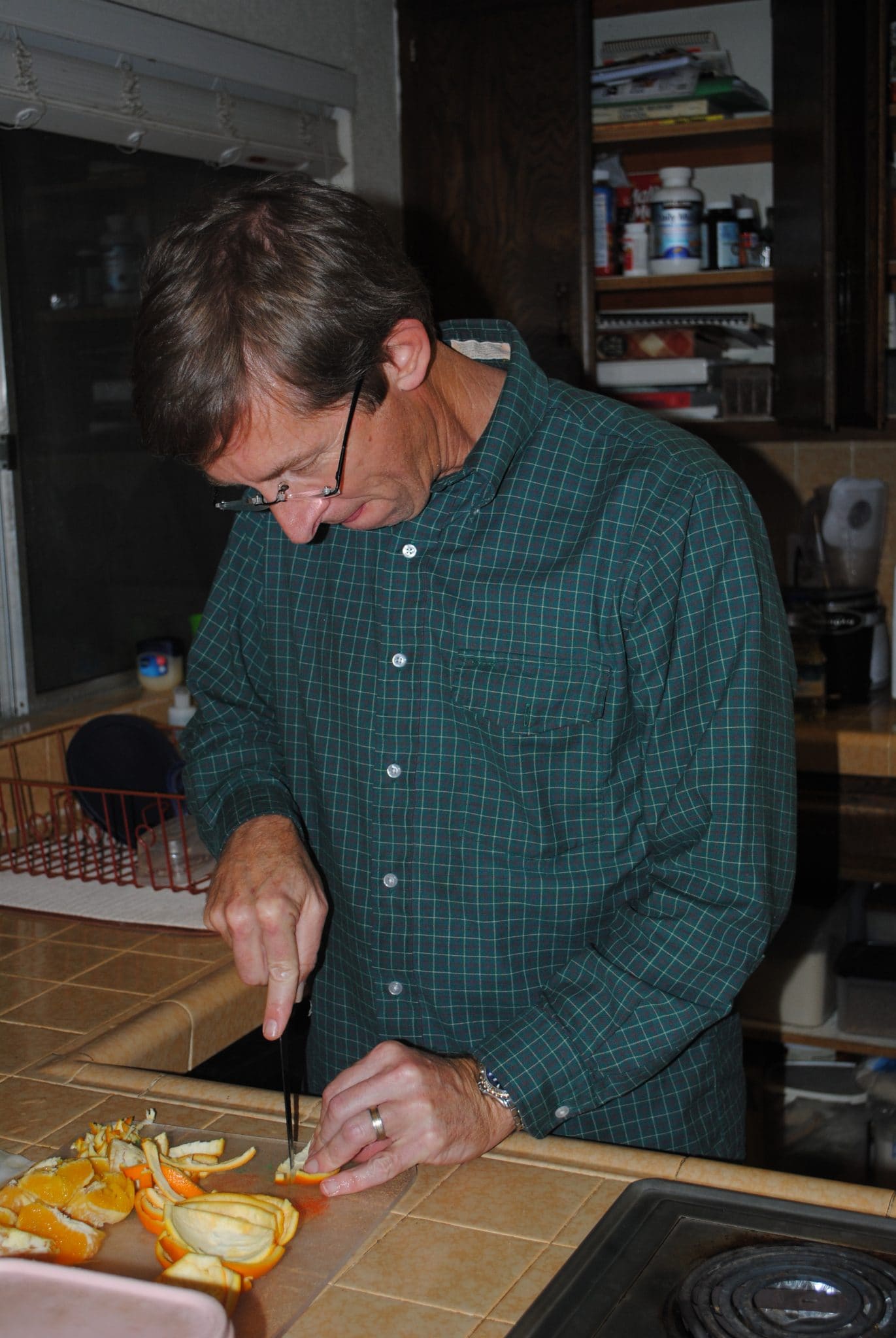 A man uses a knife to cut some cannoli.
