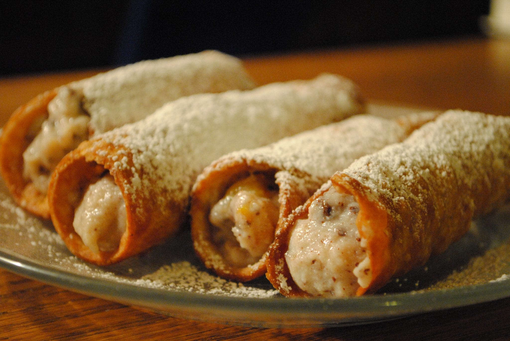 Side view of stuffed cannoli on a plate.