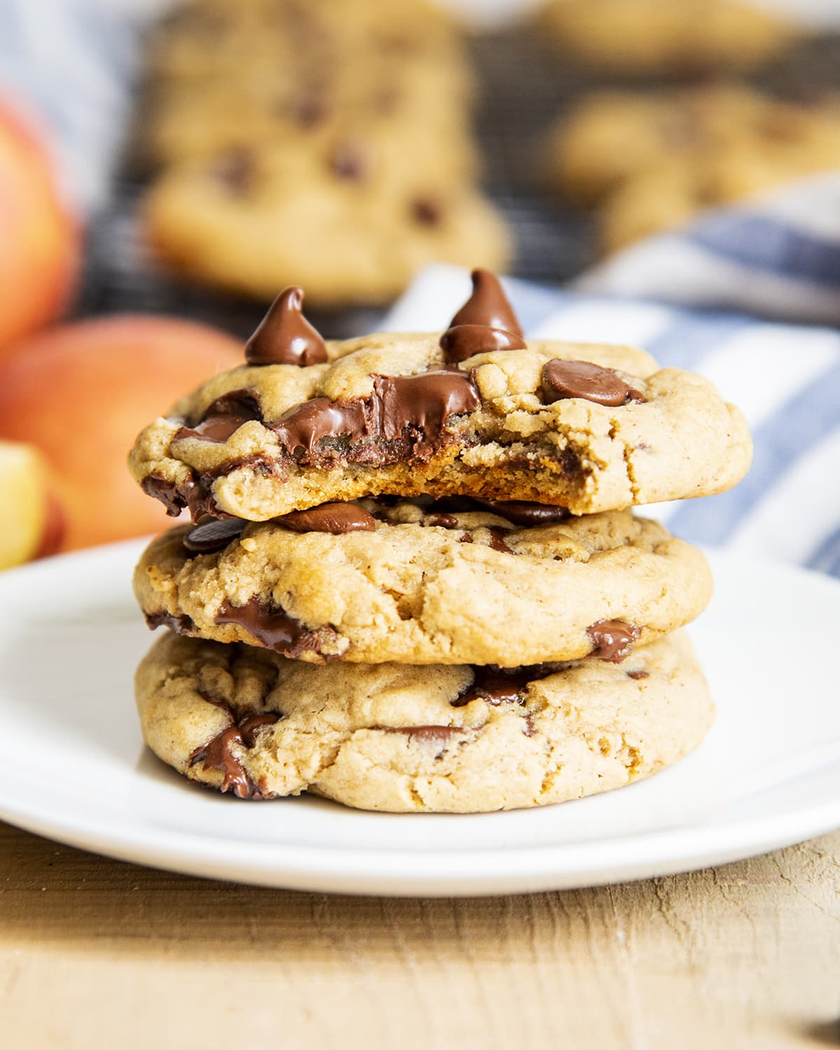 A stack of three applesauce cookies with chocolate chips. The top cookie has a bite out of it.