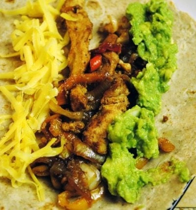 Angled views of chicken fajitas in a tortilla.