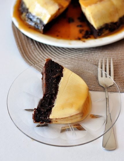 Top view of chocolate flan on a glass plate with a fork.