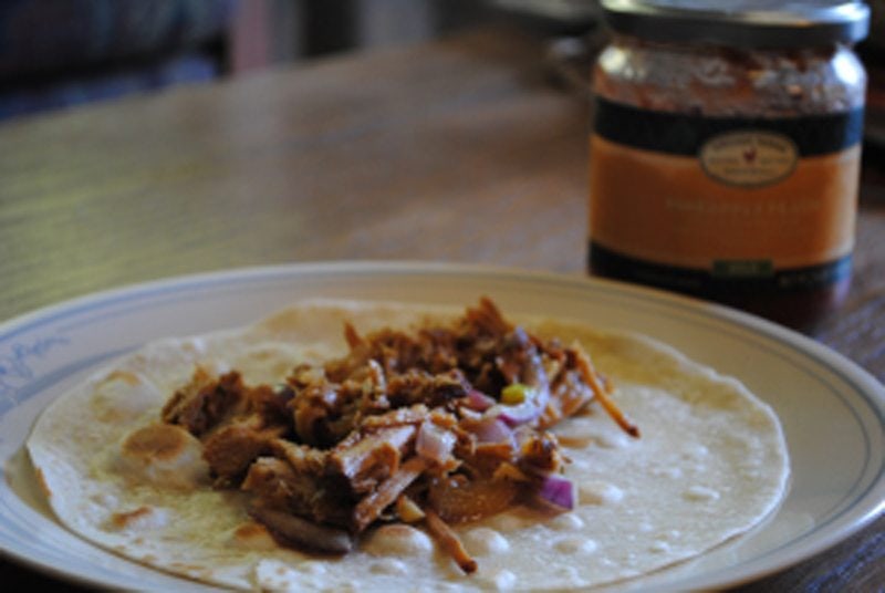Angled view of pork tacos on a plate.
