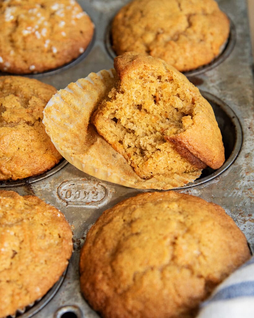 A carrot cake muffin with a bite out of it.