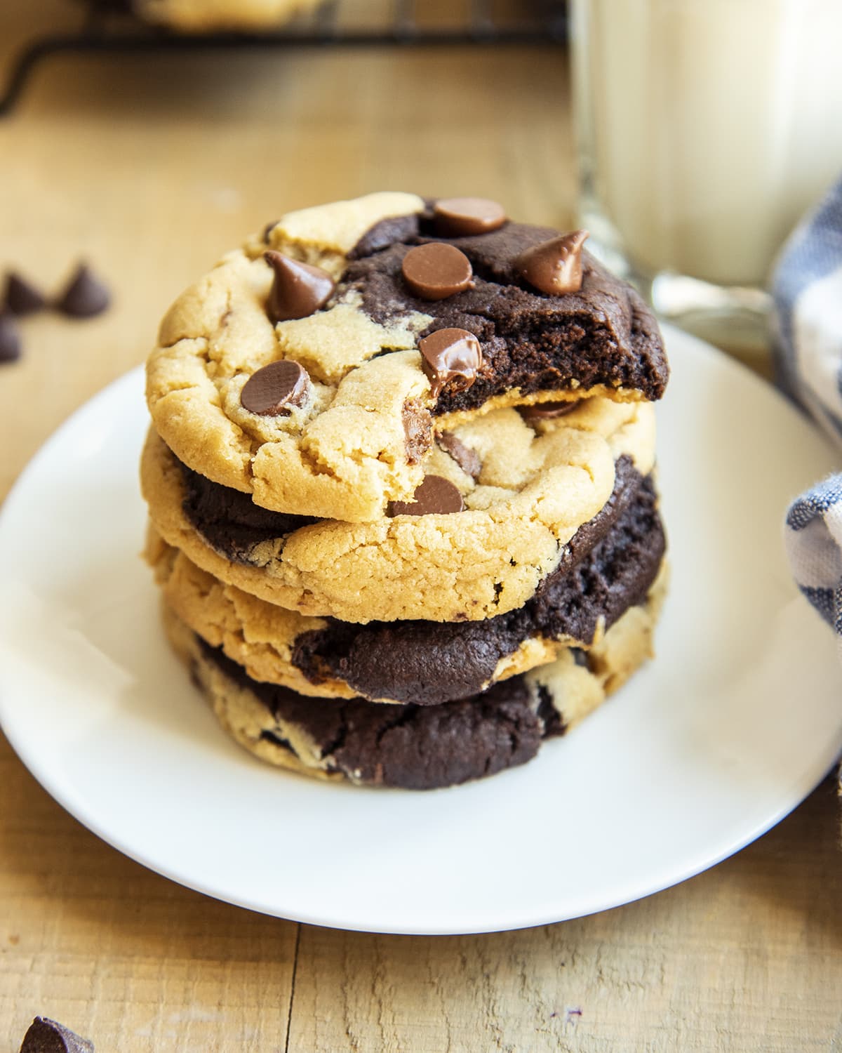 A stack of chocolate peanut butter marbled cookies on a plate, and the top cookie has a bite out of it.
