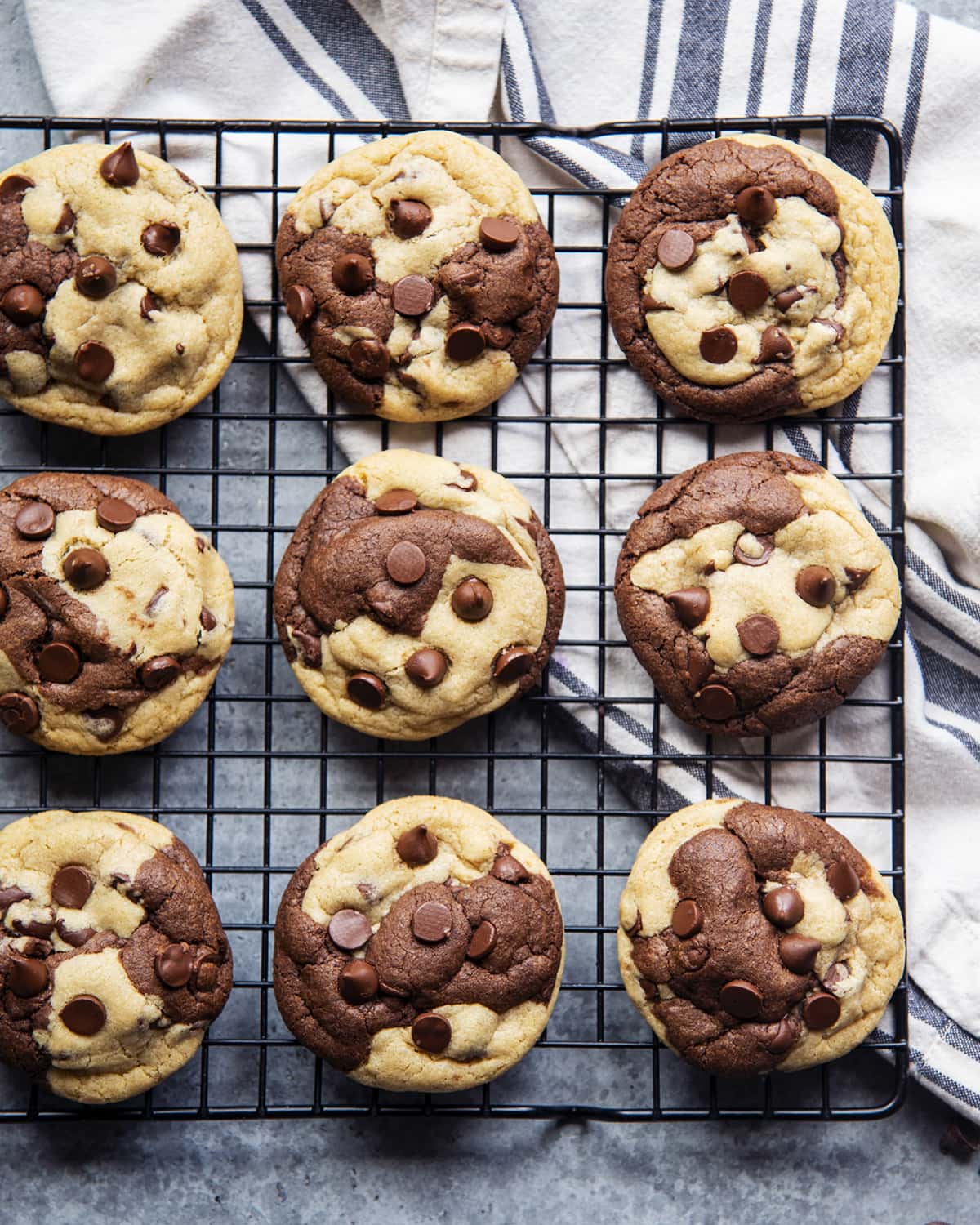 An overhead photo of a cooling rack topped with rows of chocolate chip marble cookies.