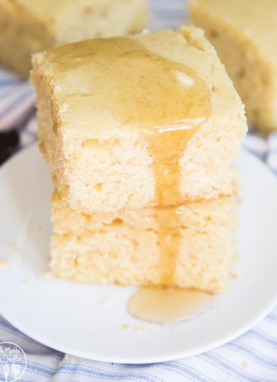 Two pieces of corn bread stacked on a plate.