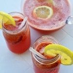 Angled view of strawberry lemonade in mason jars.