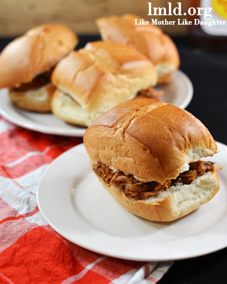 Front view of bbq sandwiches on a white plate.