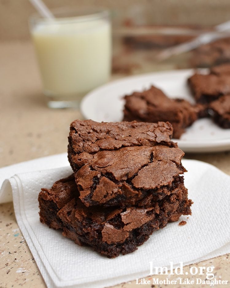 Side image of brownies stacked on a white napkin.