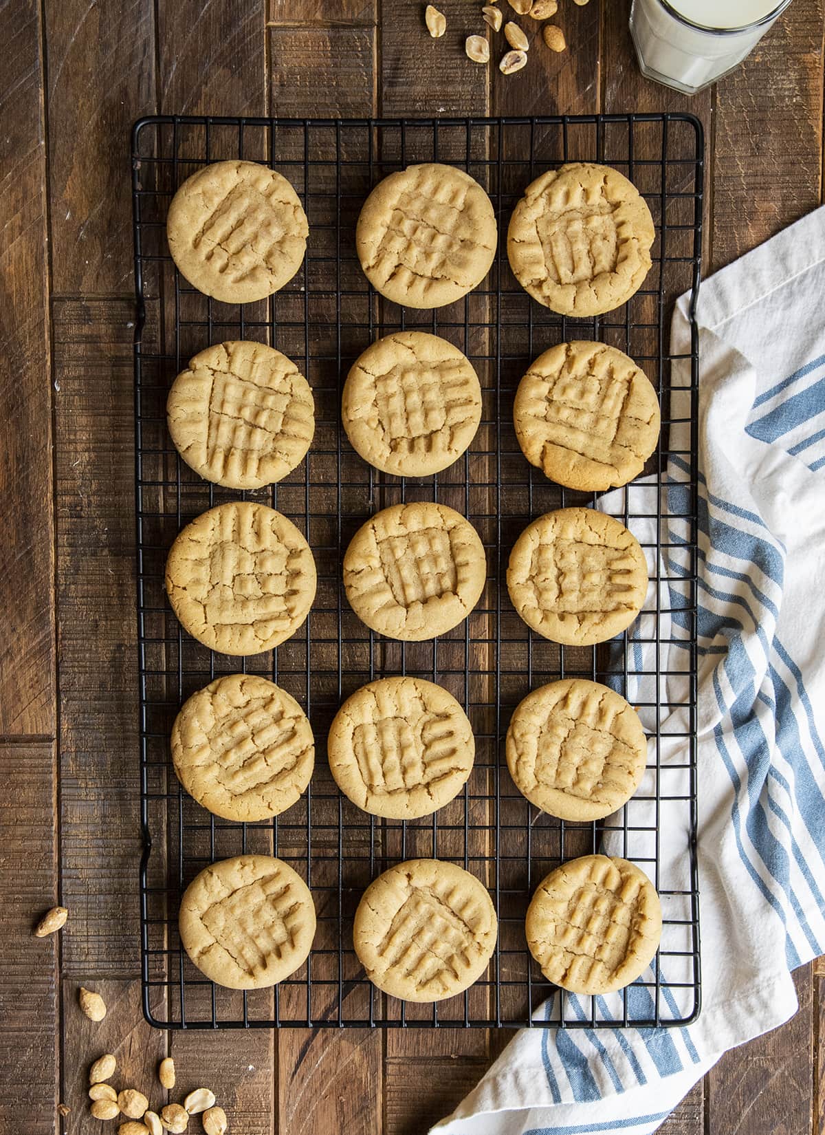 An overhead photo of a cooling rack topped with rows of peanut butter cookies.