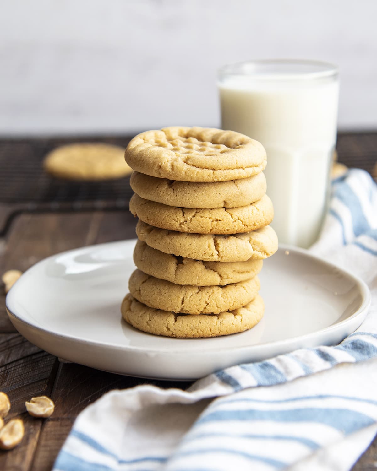 A stack of peanut butter cookies in the middle of a white plate.