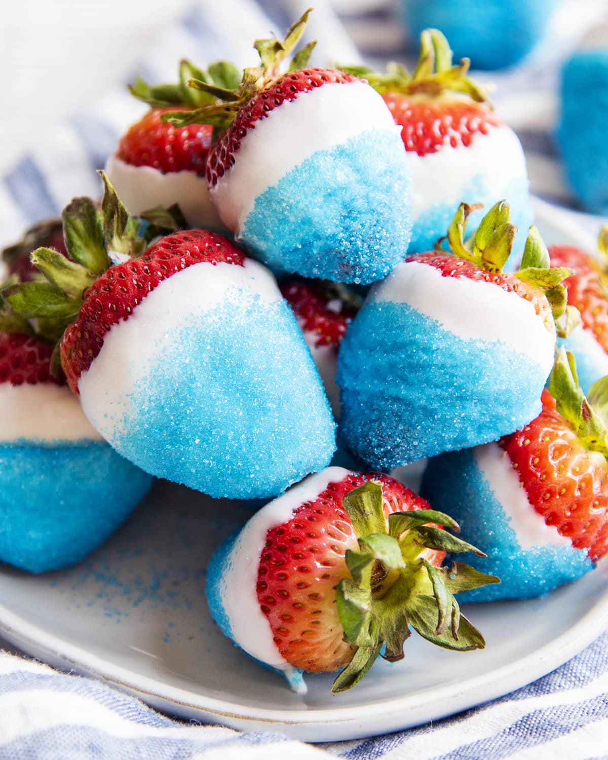 A pile of red white and blue dipped strawberries on a plate.