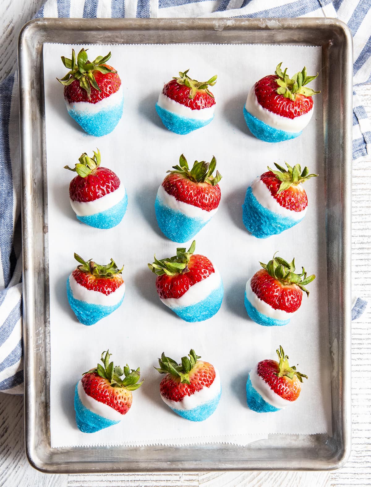 Rows of Fourth of July dipped strawberries on a baking sheet.
